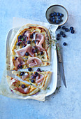Pizza with dried ham (prosciutto) and blueberries