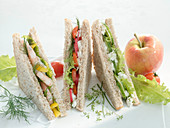 Three sandwiches with vegetables, crab, cottage cheese and boiled eggs