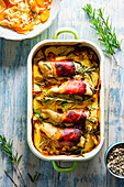 Chicken wrapped in bacon on potato gratin