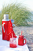 Picknick mit rotem Geschirr am Strand