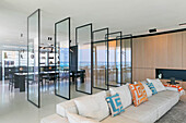 Glass room divider between lounge and dining area in a luxury penthouse