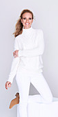 Langhaarige Frau im weißen Pullover und weißer Hose