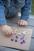 A girl playing with violet flowers