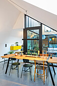 Dining table and chairs in front of glass door to courtyard in loft apartment