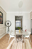 Dining room with designer furniture, floor lamp and artwork on wall with mouldings