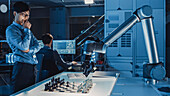Engineer playing chess with a robotic arm
