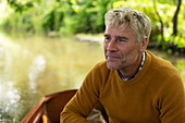 Smiling man on a boat on the river
