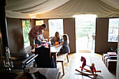 Family playing at table in yurt cabin