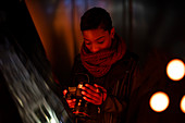 Young woman with camera at dark mirror
