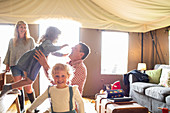 Happy family playing in yurt cabin
