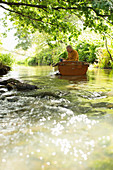 Man fly fishing in boat on river