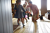 Family playing on hardwood floor in cabin