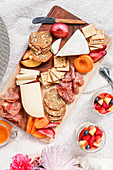 Seasonal picnic charcuterie and cheese board with crackers and fresh fruit