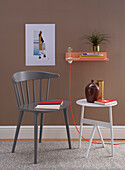 DIY-Konsole mit Glühbirne, Beistelltisch und Stuhl vor brauner Wand