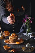 Pancakes mit Orangensaft beträufeln