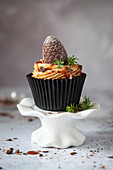 Mokka-Cupcake mit Kaffeebuttercreme, Karamellsauce und zapfenförmiger Praline