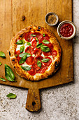 Pepperoni Pizza on wooden cutting board on stone travertine background