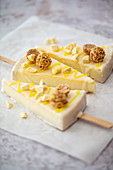 Cheesecake pops with nut pralines and vanilla icing