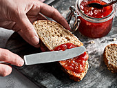 Strawberry-rhubarb jam being spread on bread