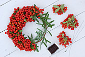 Tying a wreath of pyracantha berries