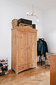 Wooden cupboard in hallway with white walls