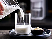 Homemade coconut milk being poured into a glass