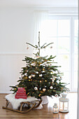 Weihnachtsbaum mit Weihnachtsdeko und antikem Schlitten