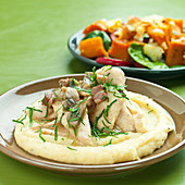 Chicken, bacon and mushroom stew on mashed potato with green herbs