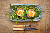 Scotch eggs on rocket leaves