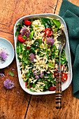 Salat 'To Go' mit Orzo-Nudeln, Rucola und Schnittlauchblüten