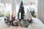 Metal basket as an Advent wreath with Christmas tree baubles, pewter star, gnomes and tiny trees
