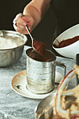 Kakaopulver in Sieb füllen