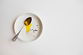 Olive oil and peppercorns on a white plate