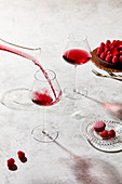 Rotwein wird aus Glaskaraffe in Weingläser eingegossen