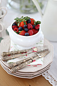 Summer berries and silver fork on stack of plates