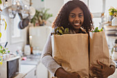 Young woman with groceries in kitchen