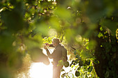 Man preparing fly fishing pole at sunny riverbank