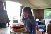 Girl looking at strawberry cake in yurt cabin