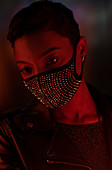 Young woman in face mask in dark red light