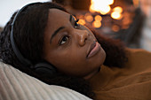 Woman listening to music by fireplace