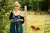 Proud woman with blackberries in summer garden