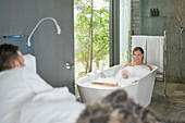Happy couple relaxing in luxury hotel room with soaking tub