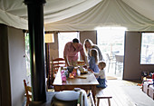 Family at dining table with strawberry cake on yurt tent