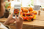 Florist photographing autumn display using a smartphone
