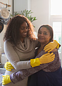 Mother and daughter in rubber cleaning gloves hugging