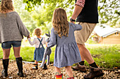 Girl with stuffed animal holding hands with father on path