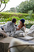 Couple relaxing with coffee on luxury patio cushions