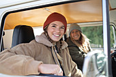 Happy young women friends inside camper van