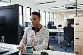 Businesswoman working at computer in open plan office