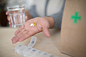 Woman holding prescription medication and glass of water
